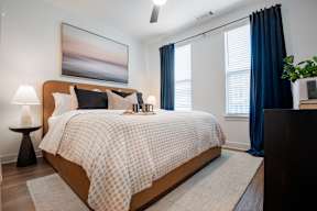 A bedroom with a large bed and a painting on the wall.