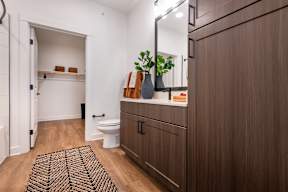 A bathroom with a brown cabinet and a white toilet.