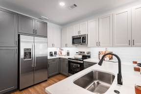 A modern kitchen with stainless steel appliances and white cabinets.