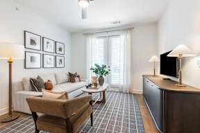 A living room with a couch, chair, and a television.