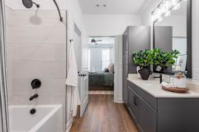 A bathroom with a white tub and a white sink.