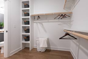 A white closet with a basket and hangers.