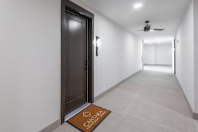 A hallway with a brown door mat that says "Cantor".