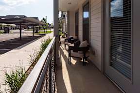 A balcony with a chair and a table.