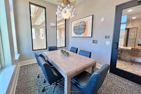 A dining room with a wooden table and blue chairs.