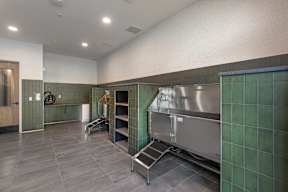 A kitchen with a stainless steel refrigerator and green tiled walls.