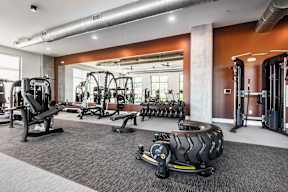 A gym with a variety of equipment including weights and machines.
