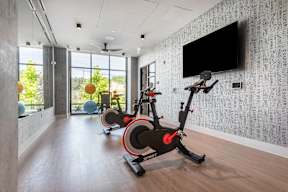A room with a wallpapered wall and a television mounted on it.