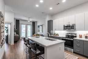 A modern kitchen with a large island and stainless steel appliances.