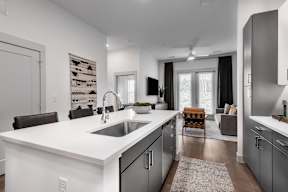A modern kitchen with a white countertop and black cabinets.