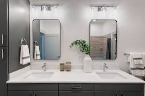 A bathroom with two sinks and two mirrors.
