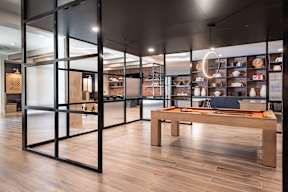 A room with a long table and a display of bowls on the wall.