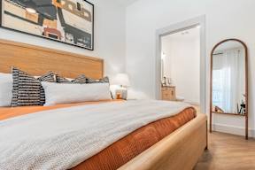 A bedroom with a large bed and a painting on the wall.