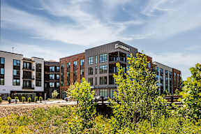 A building with the word "CONFOR" on it is surrounded by other buildings and vegetation.