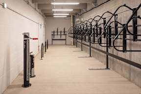 A gym with a row of black bars on the wall.