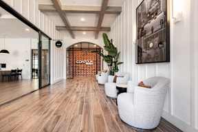 A modern living room with white furniture and a wooden floor.