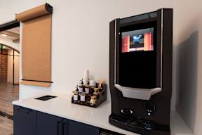 A modern kitchen with a black countertop and a black microwave.