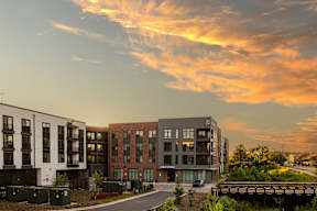 A modern apartment complex with a bridge in the foreground.