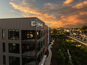 A building with the word CONTOUR on it is shown with a beautiful sunset in the background.