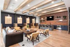 A modern living room with a black couch and wooden chairs.