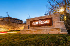 the sign for the arisian at night in front of a stone building