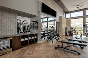 A gym with a variety of equipment including dumbbells, benches, and weights.