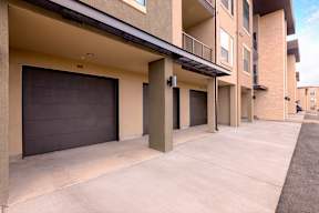 A row of apartment buildings with garage doors.