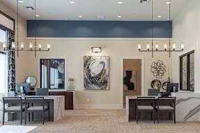 A modern home office with a large painting on the wall and a desk with a laptop and a chair.