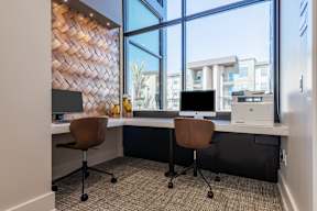 A modern office with two chairs and a desk with a computer.