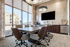 A conference room with a large table and chairs.