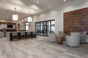 A modern living room with a bar area and a dining table.