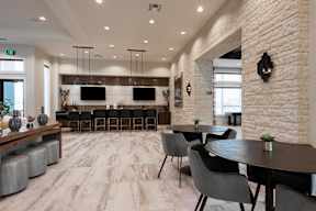 A modern dining room with a long table and chairs.