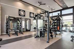 A spacious gym with a variety of equipment and a ceiling fan.
