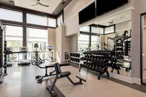 A gym with a variety of equipment including weights and machines.