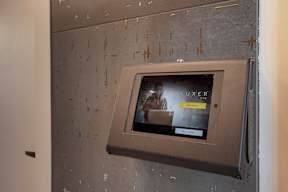 A wall-mounted television displays an advertisement for a luxury product.