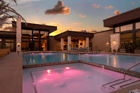 A swimming pool in a residential area with a house in the background.
