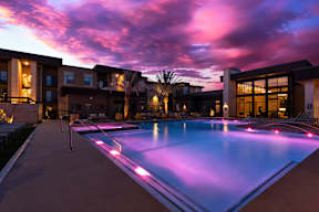 A swimming pool with a purple light reflection in the water.