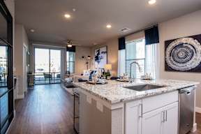 A modern kitchen with a marble countertop and stainless steel appliances.