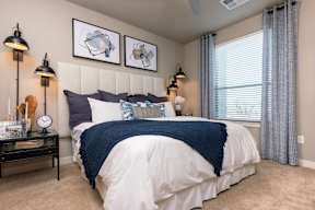 A bedroom with a white bed and blue blanket.