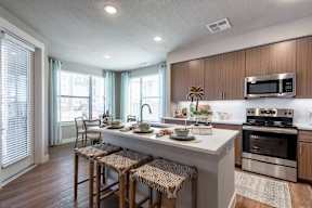 A kitchen with a white countertop and stainless steel appliances.