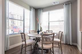 A dining room with a table and chairs.