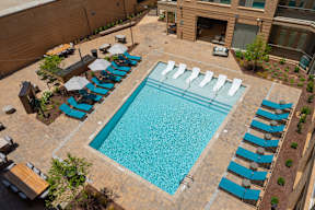 A large swimming pool surrounded by sun loungers.