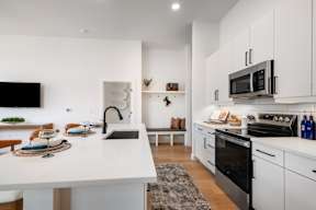 A modern kitchen with white cabinets and a black oven.