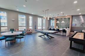 A modern dining room with a pool table and a view of the city.