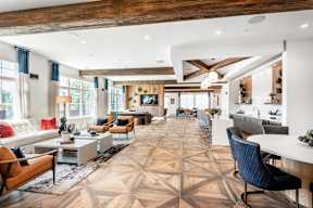 A spacious living room with a large rug and a variety of seating options.