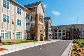 A large apartment complex with a road in front.