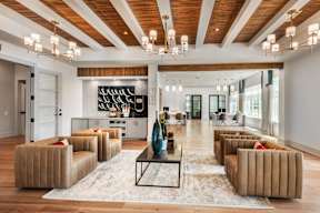 A modern living room with a wooden ceiling and a rug on the floor.