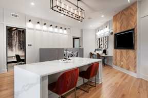 A modern dining room with a white table and red chairs.