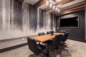 A conference room with a wooden table and chairs.