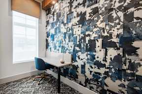 A blue and white abstract painting covers a wall in an office.